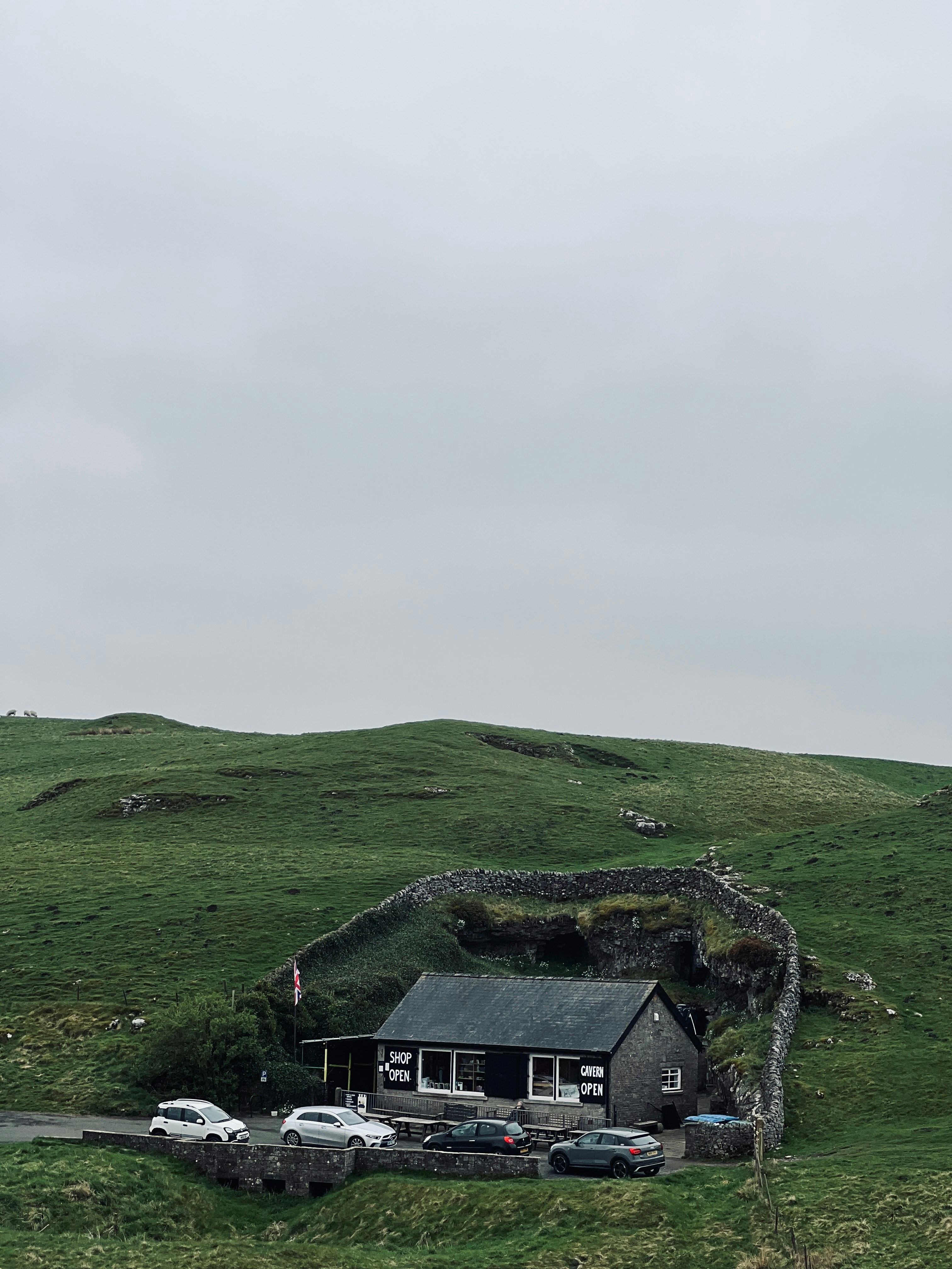 a house on a hill with cars parked in front of it