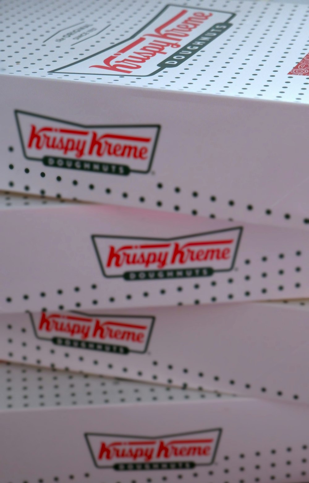 Três caixas de Krispy Kreme são empilhadas umas sobre as outras