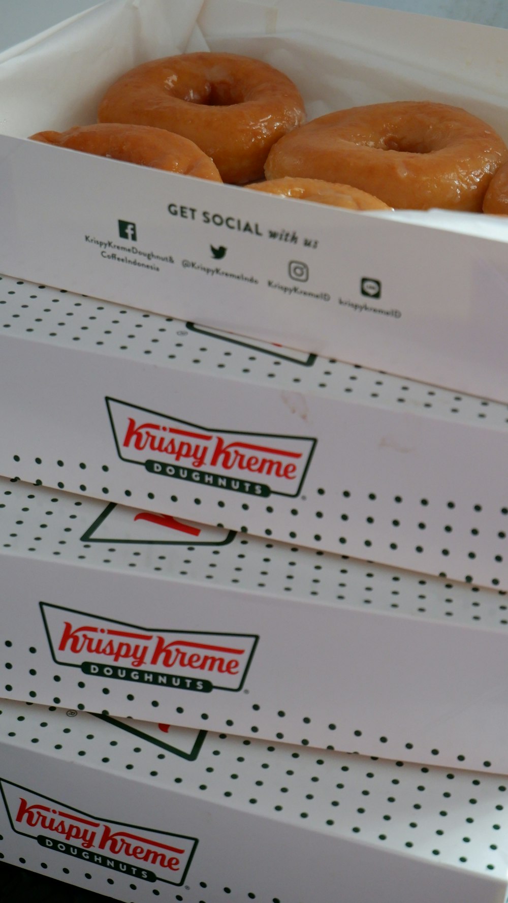 Vier Schachteln glasierte Donuts mit Krispy-Kreme