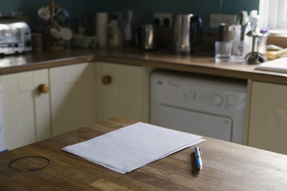 a kitchen counter with a napkin and a pen on it