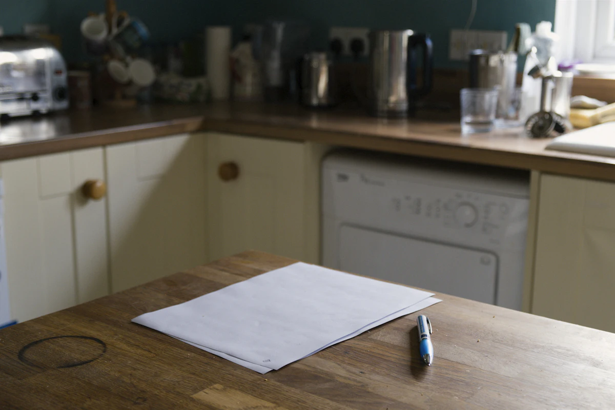 Hands reviewing a listing agreement on a kitchen island