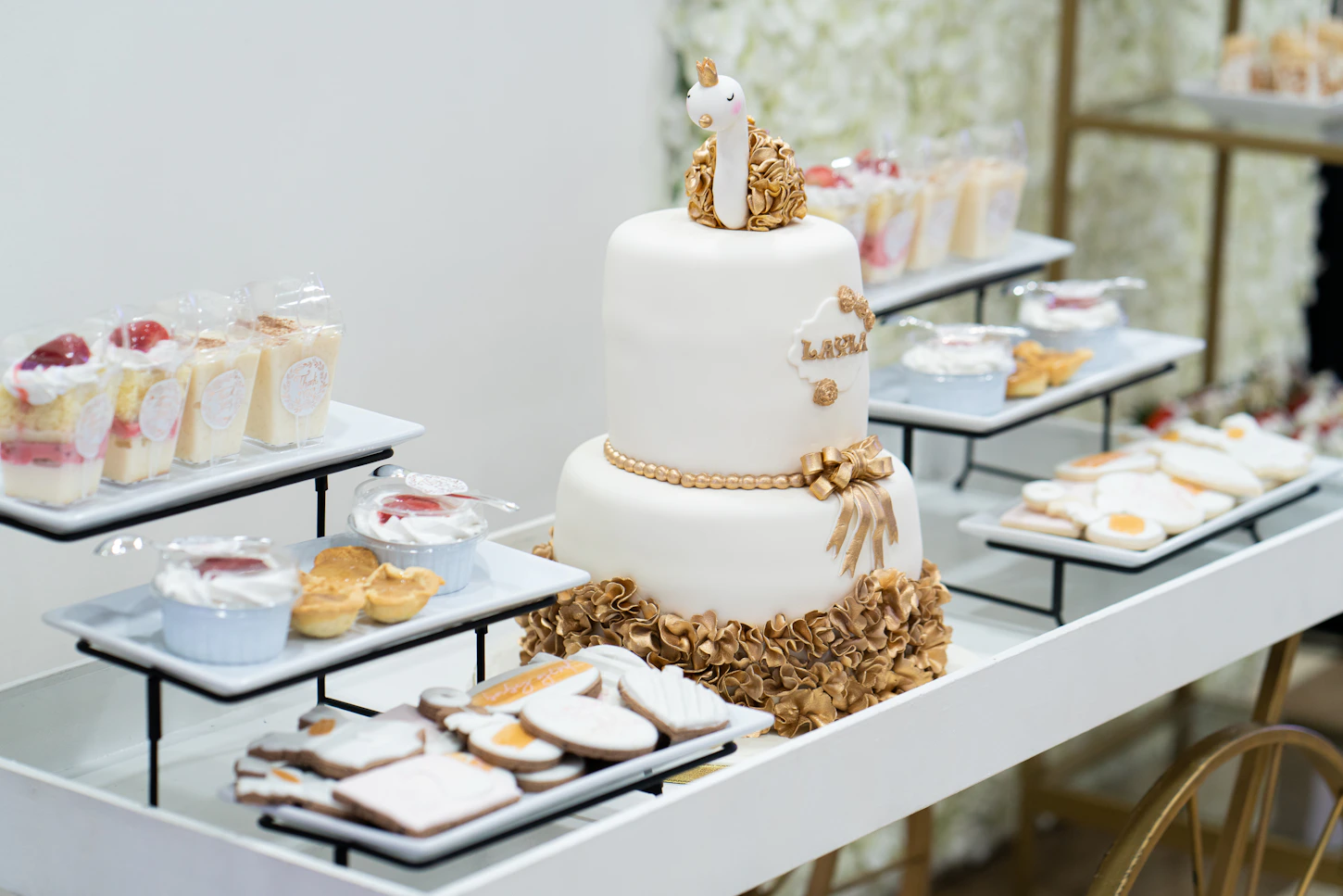 Celebration dessert table with a white cake and arranged sweets