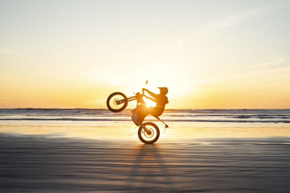 uma pessoa pulando uma bicicleta de terra no ar