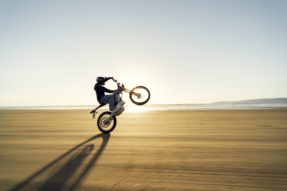 uma pessoa pulando uma bicicleta de terra no ar