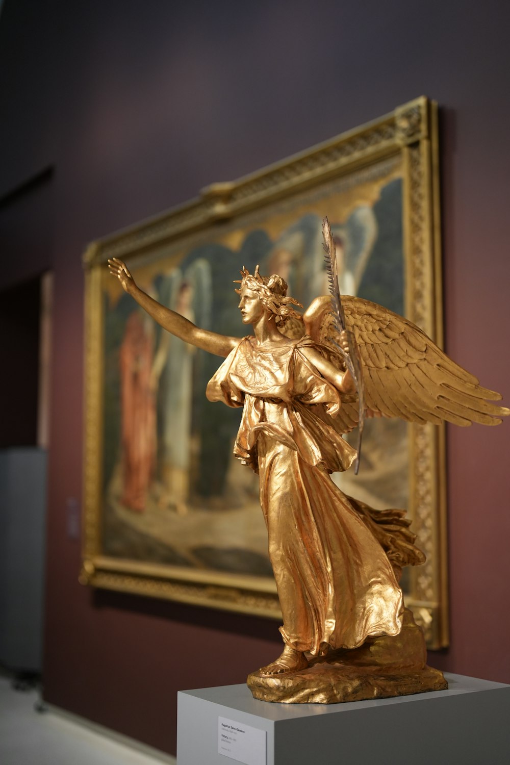 a golden statue of an angel holding a staff