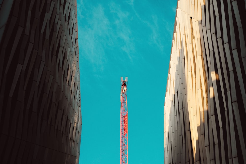 a tall red tower sitting between two tall buildings