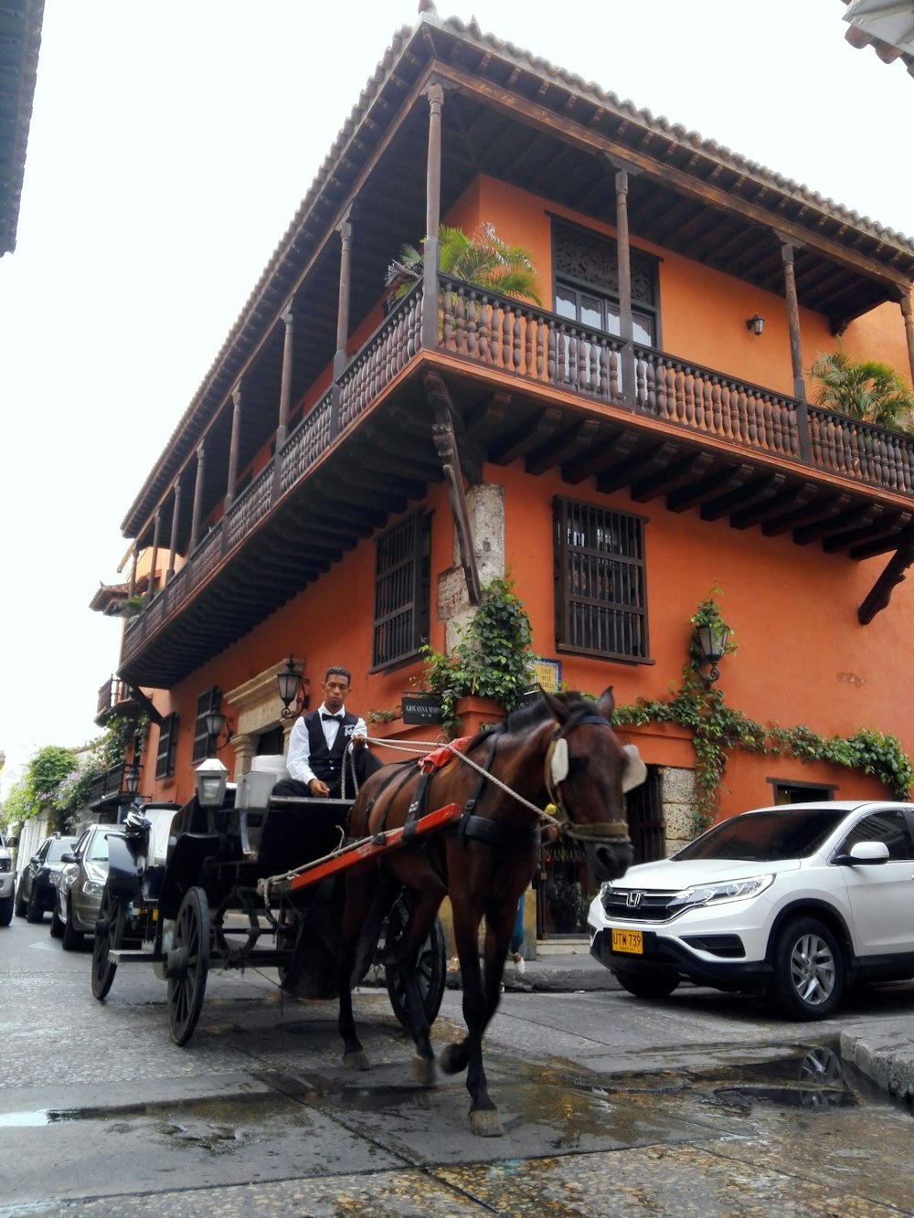 a horse drawn carriage in front of an orange building