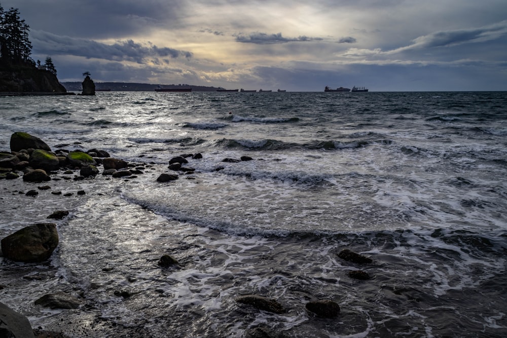 a body of water surrounded by rocks under a cloudy sky