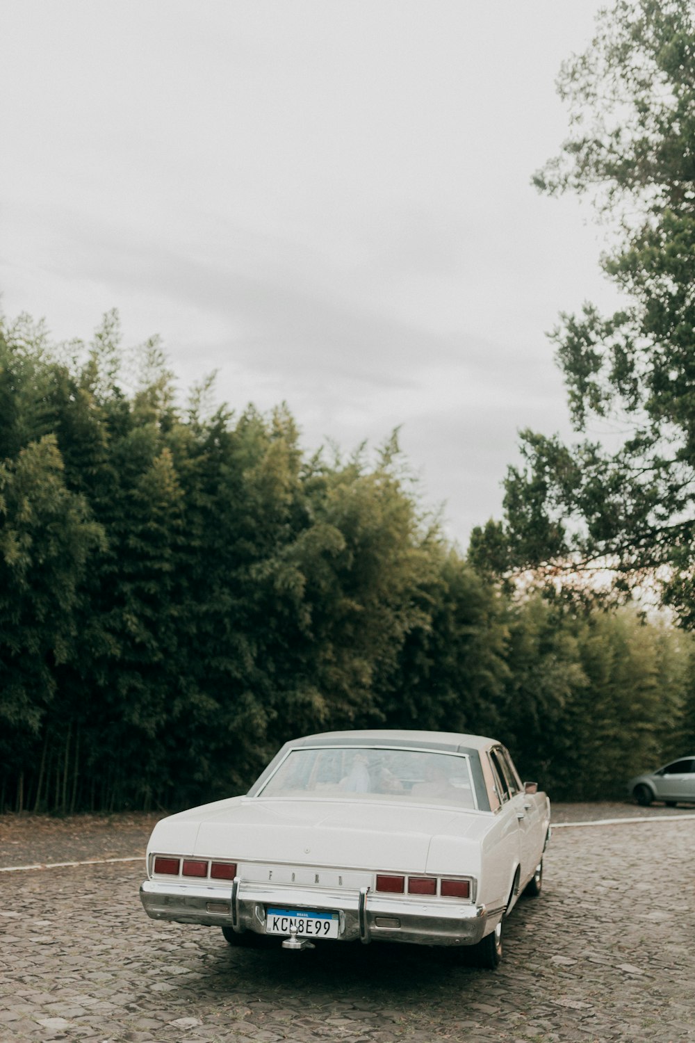 a white car parked on a gravel road