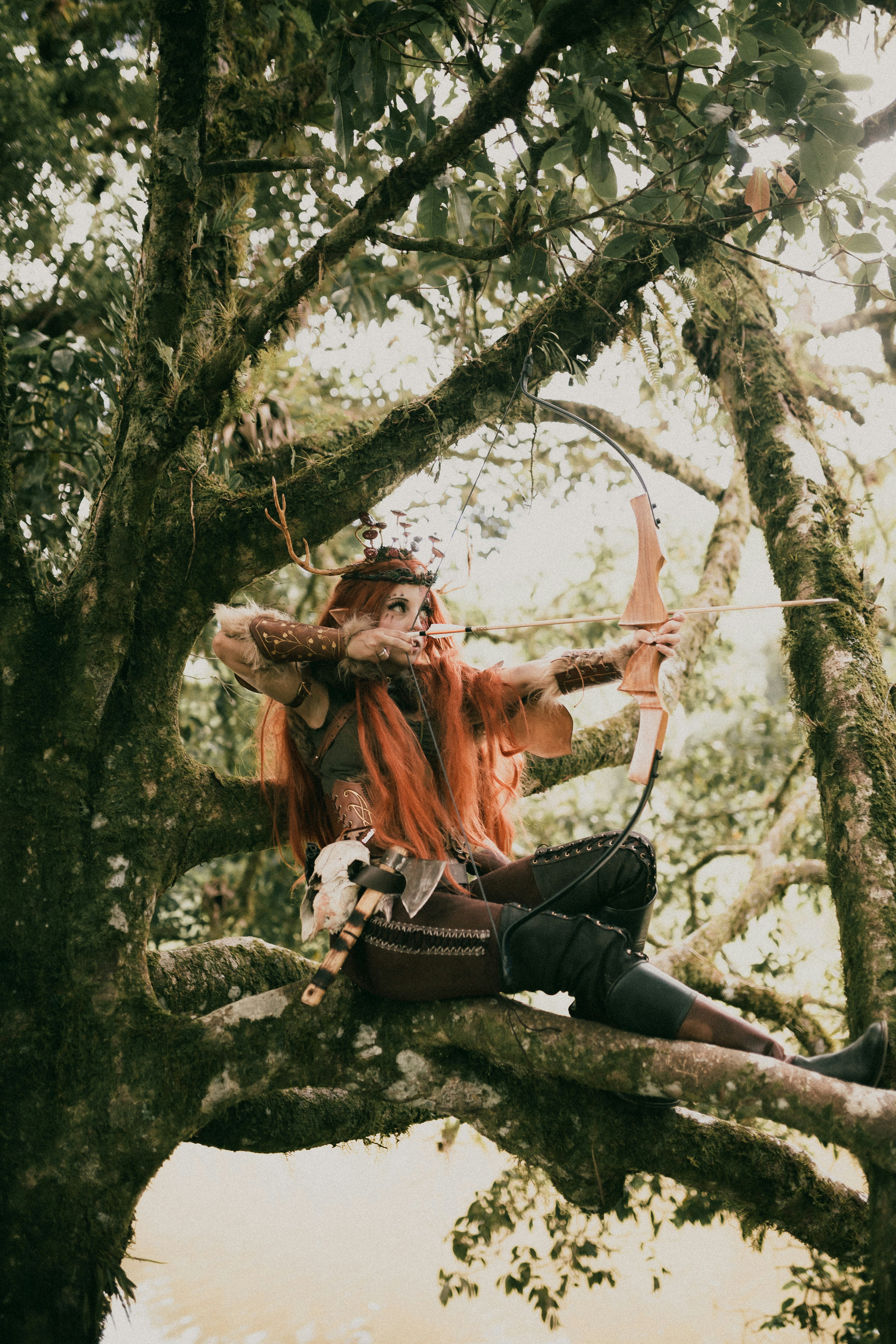 나뭇가지에 앉아 있는 빨간 머리의 여자