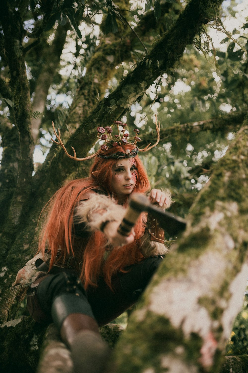 a woman with red hair wearing a crown and holding a knife