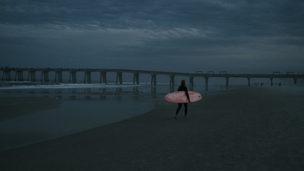 a person holding a surfboard on a beach