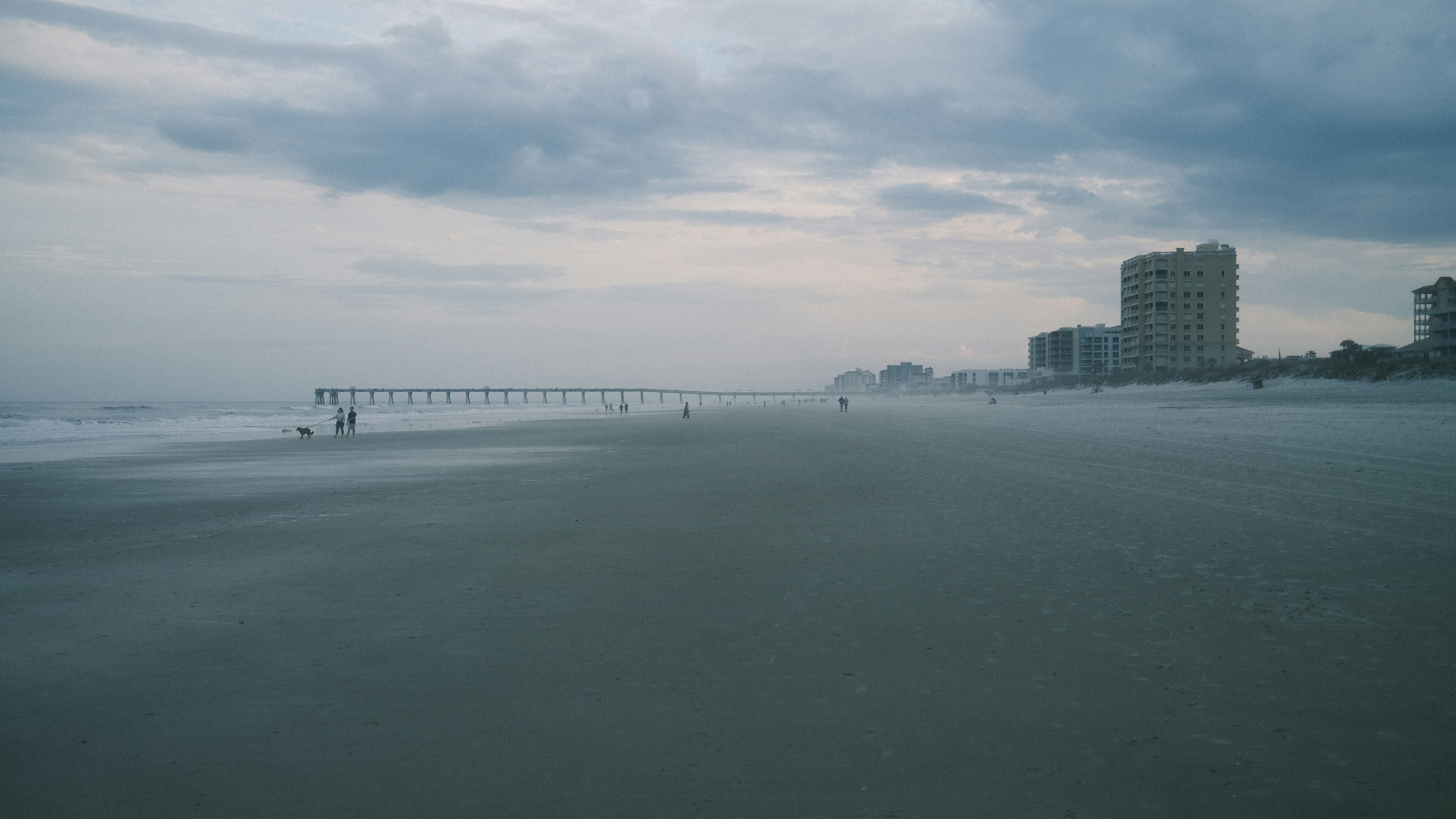 a person walking on a beach next to the ocean