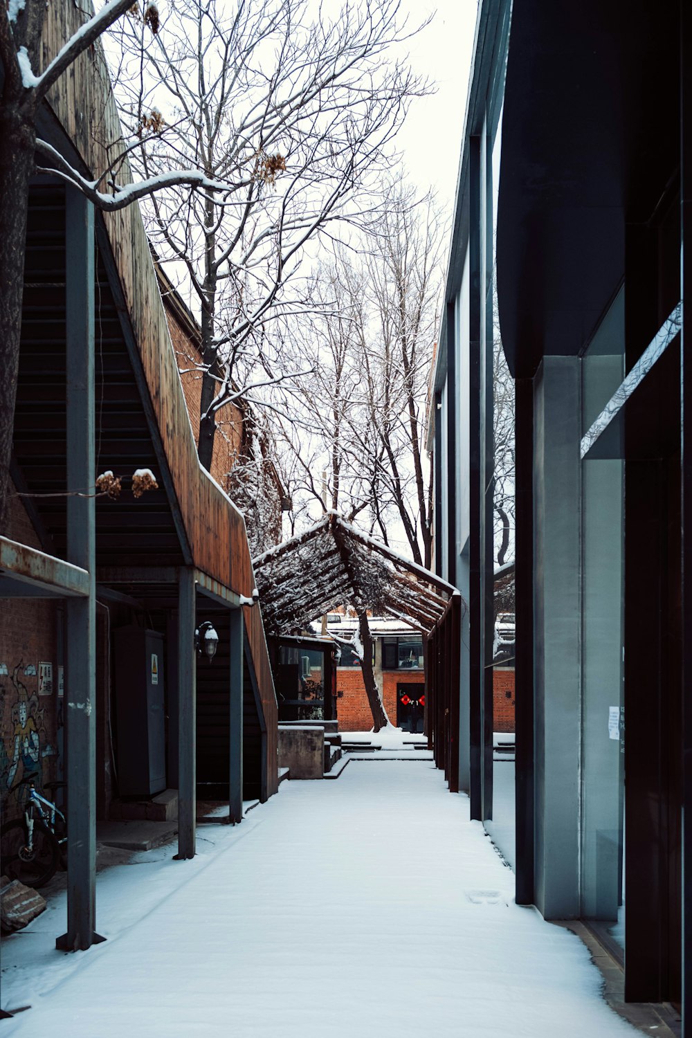 a snow covered walkway between two buildings