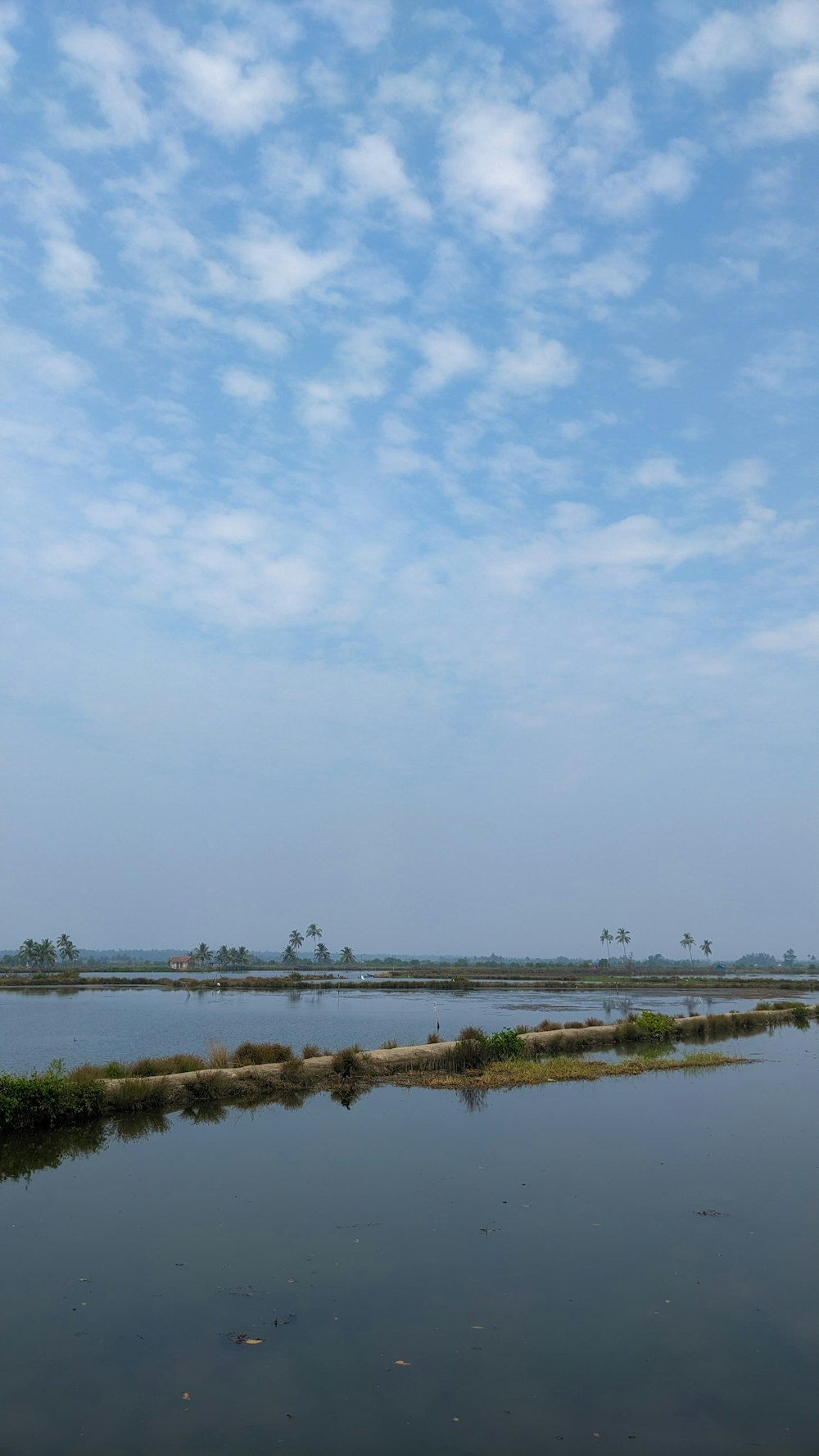 a large body of water with a sky in the background