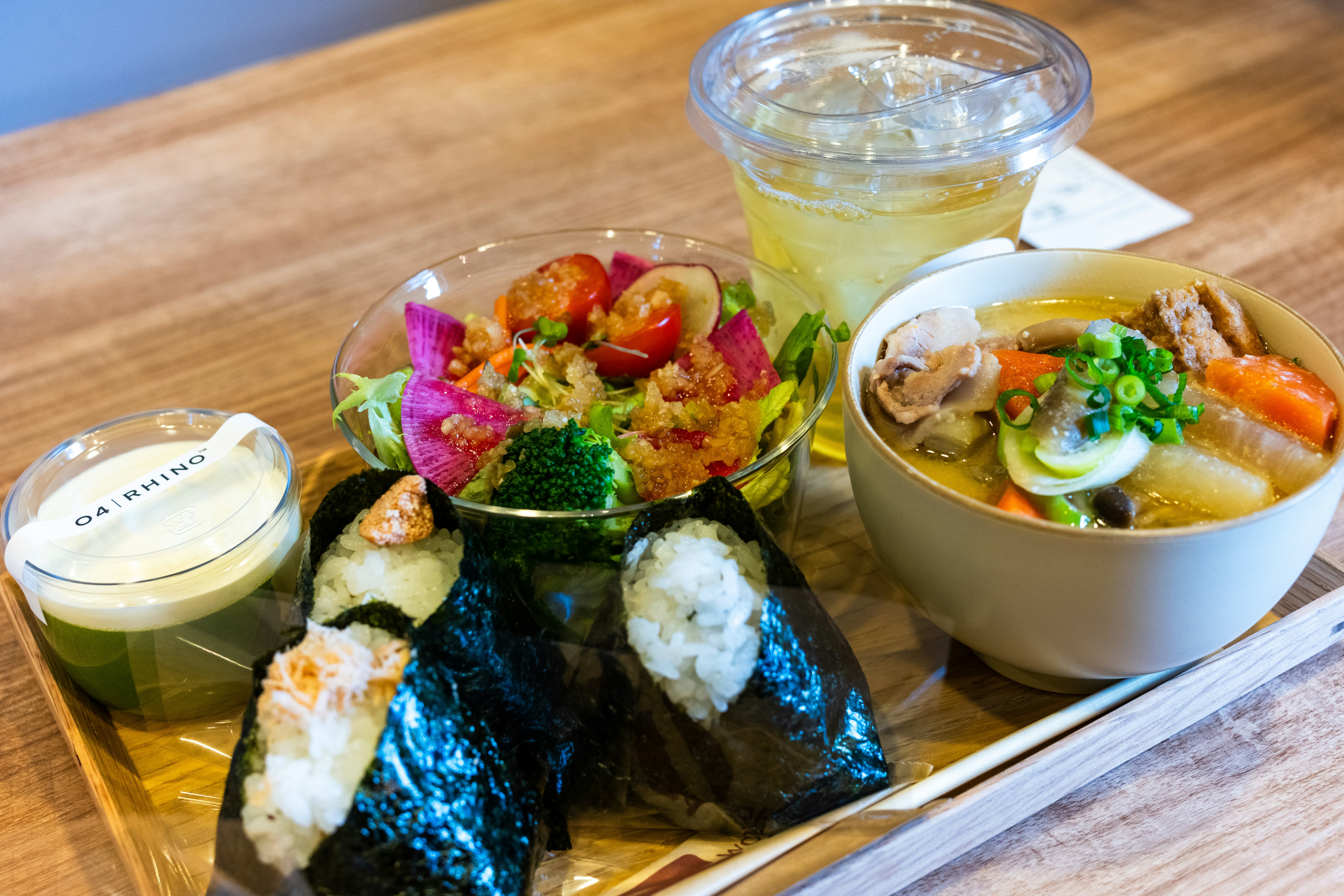 Onigiri rice balls beside bowls of soup