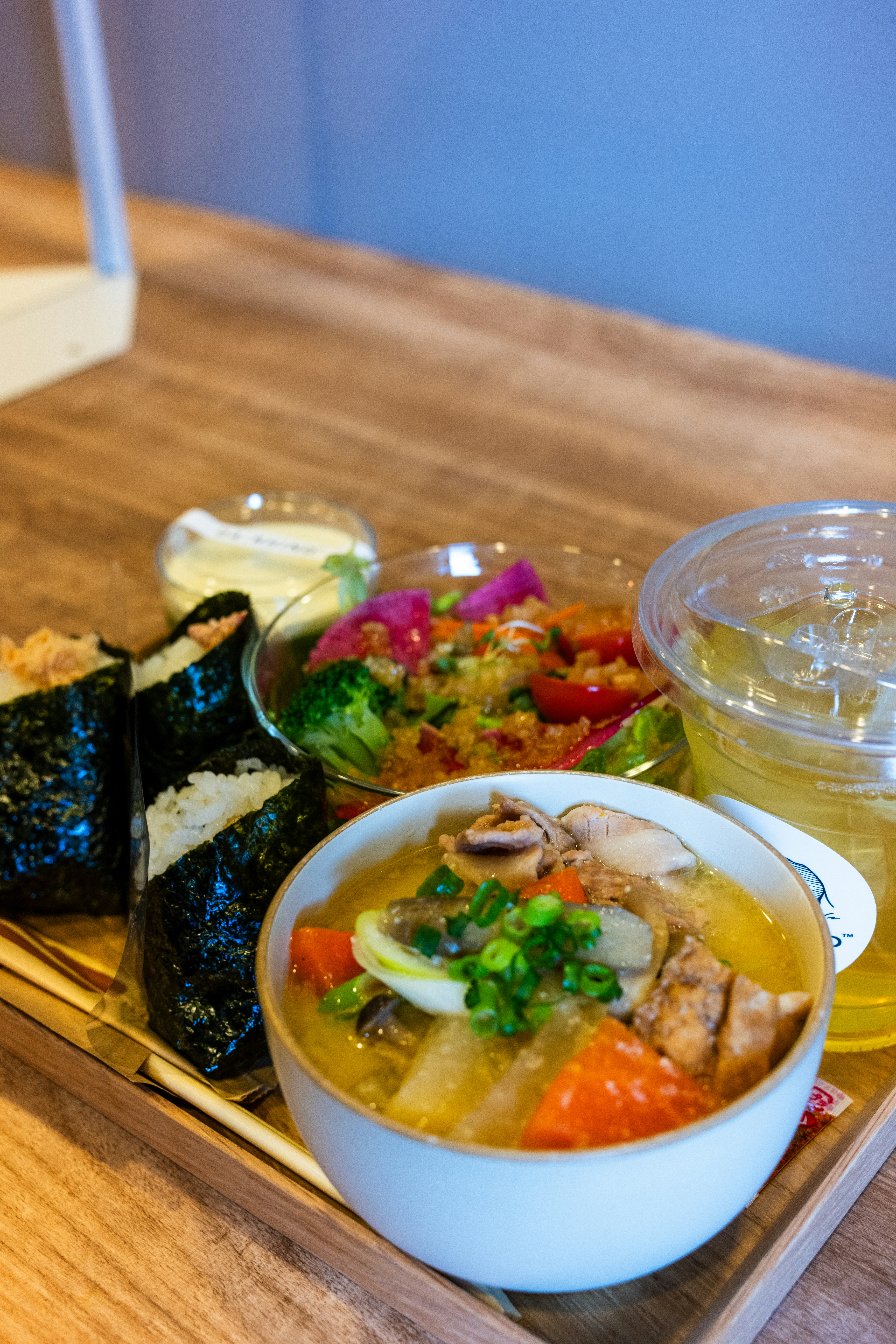 a wooden table topped with a bowl of soup