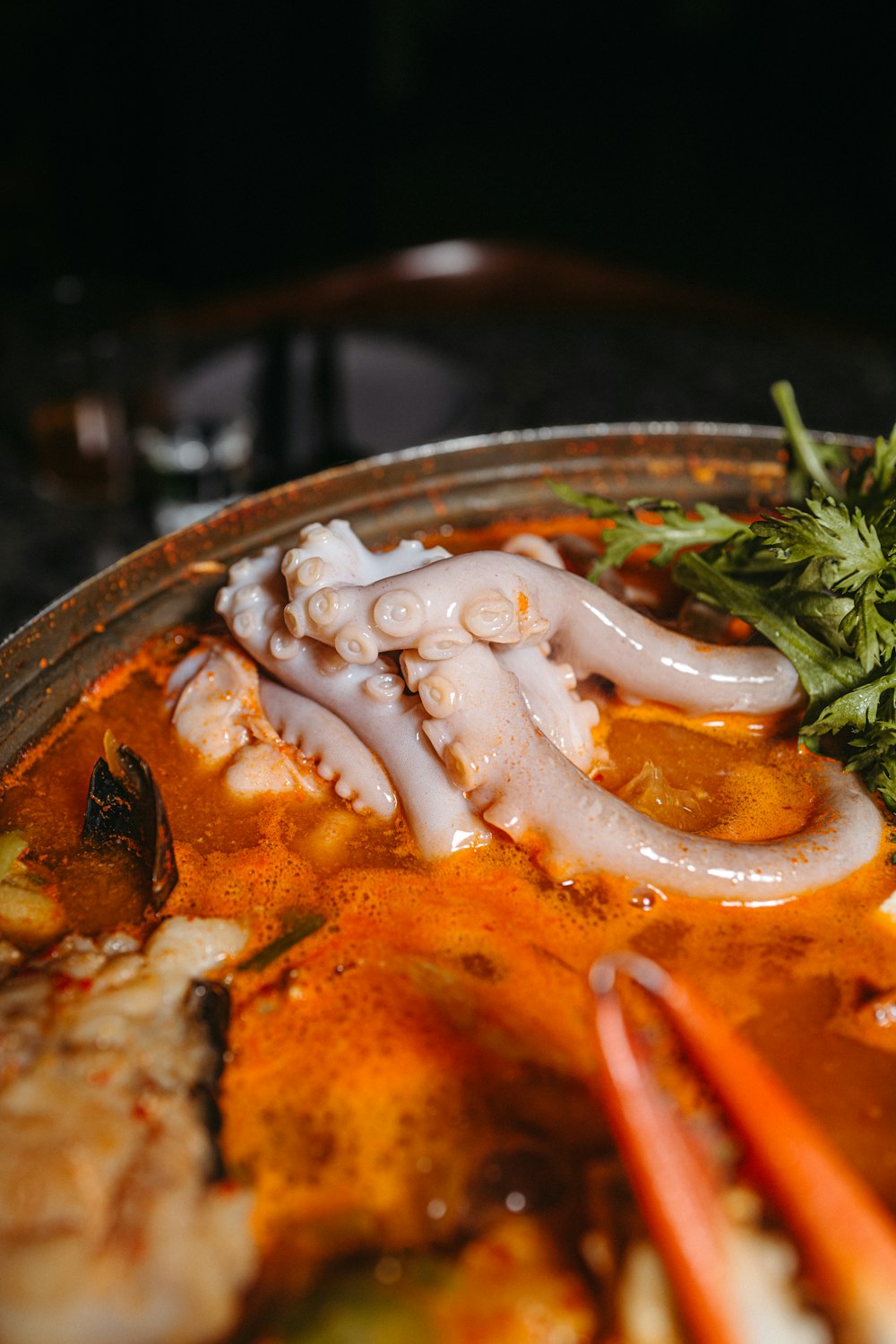 a bowl of soup with an octopus in it