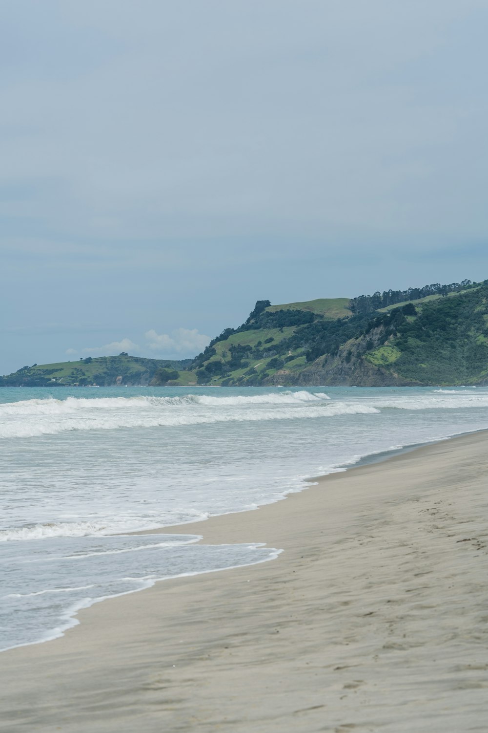 a person walking on a beach with a surfboard