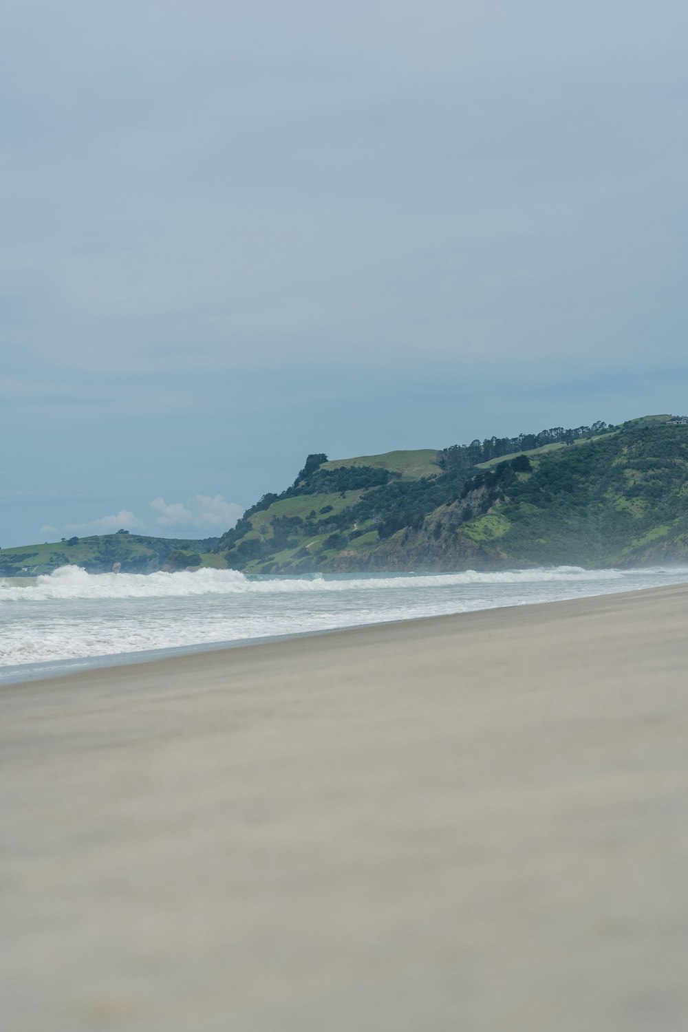 a person walking on a beach carrying a surfboard