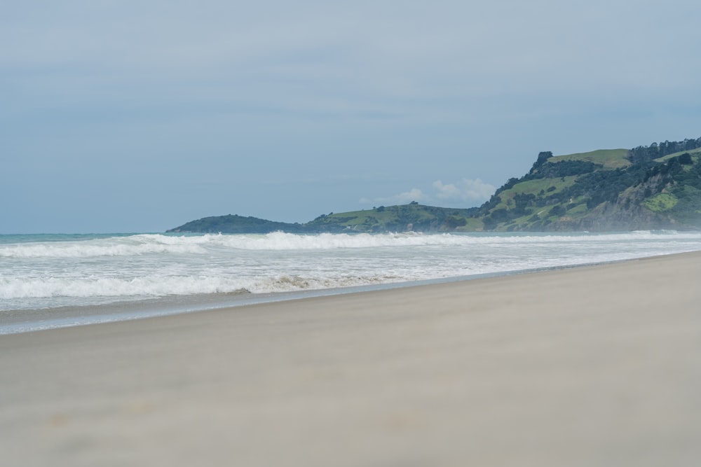 a person walking on a beach near the ocean