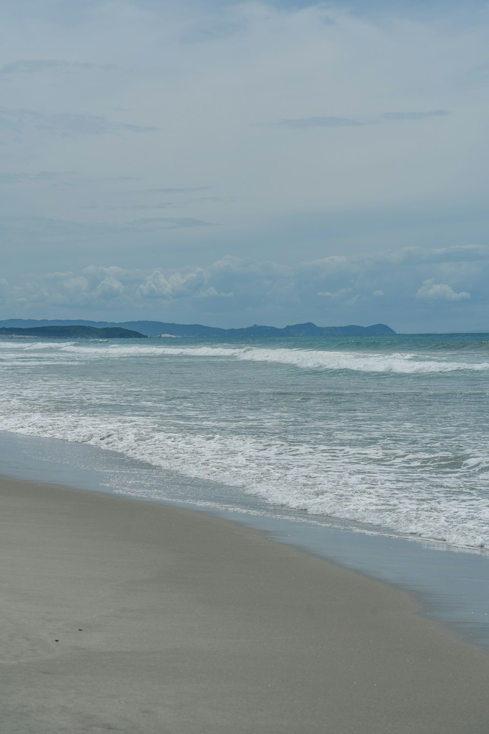 a person walking on the beach with a surfboard