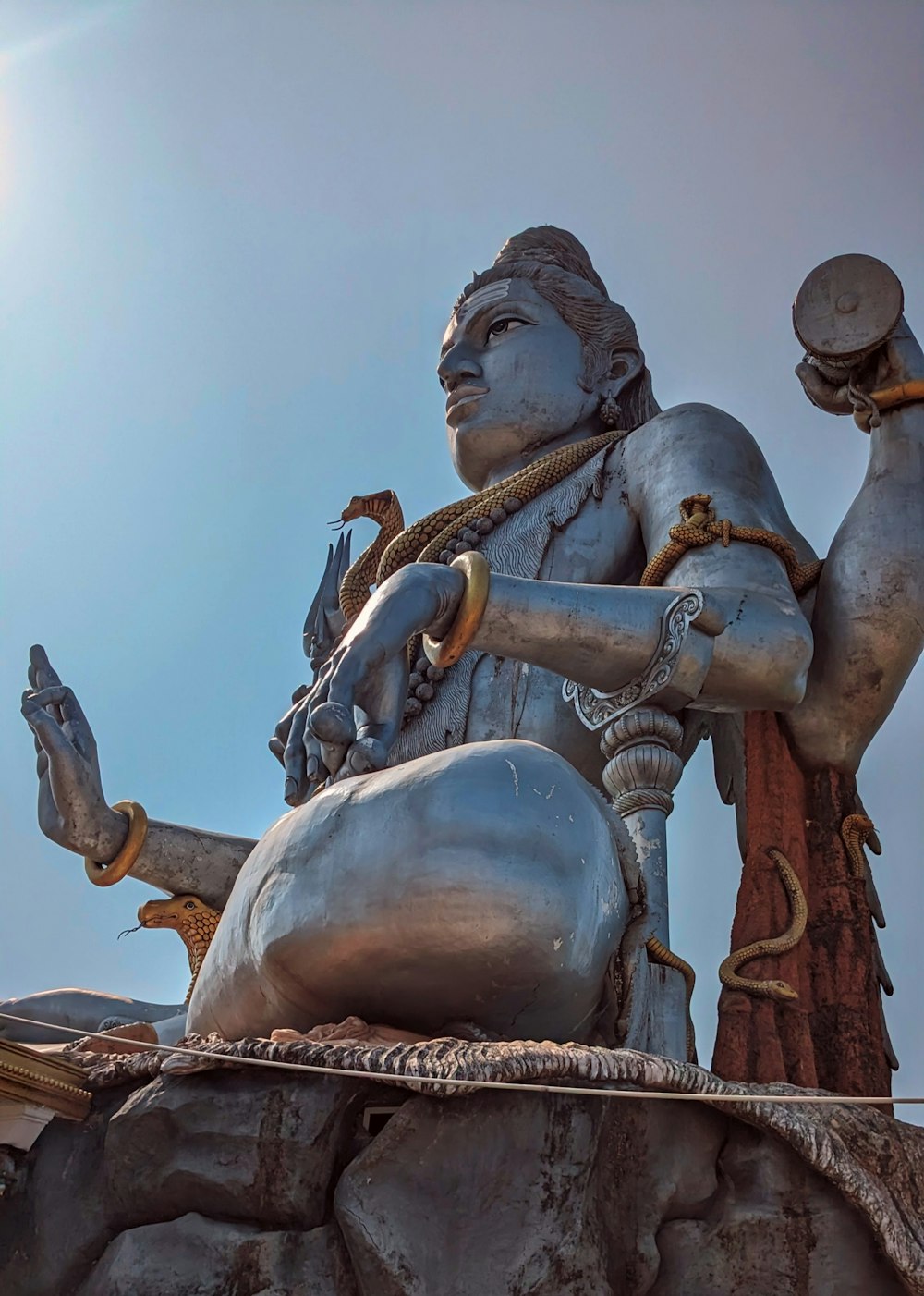 a statue of a man sitting on top of a rock