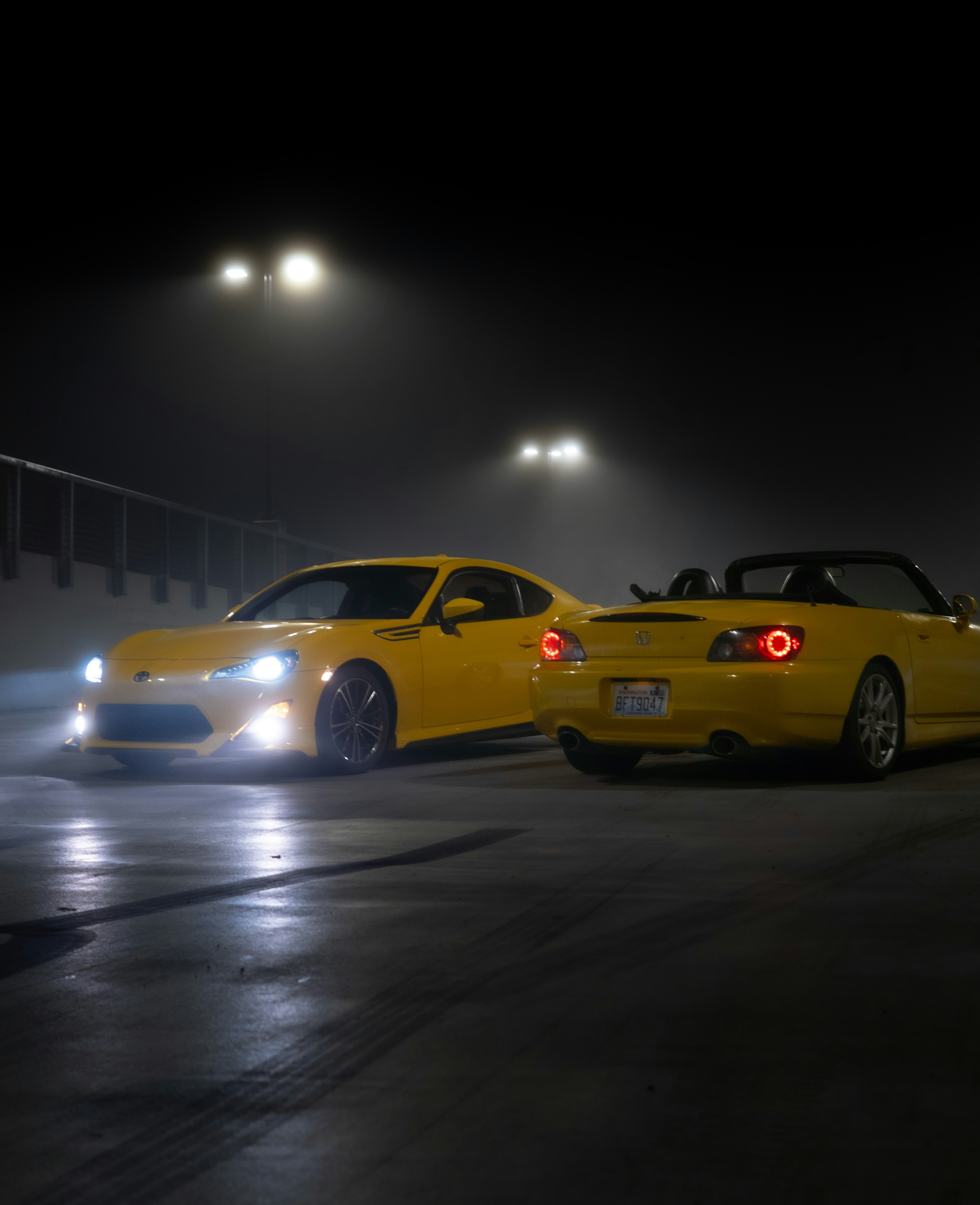 a couple of yellow cars parked next to each other