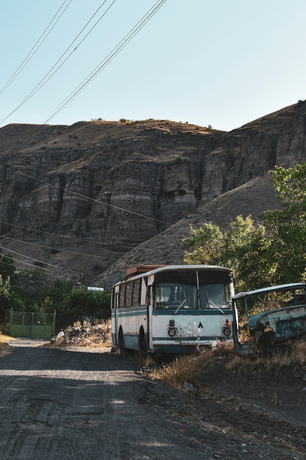 a bus parked on the side of a dirt road