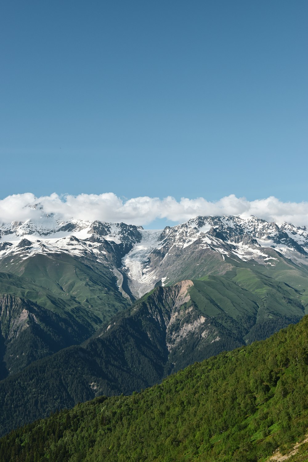 a mountain range with snow capped mountains in the distance