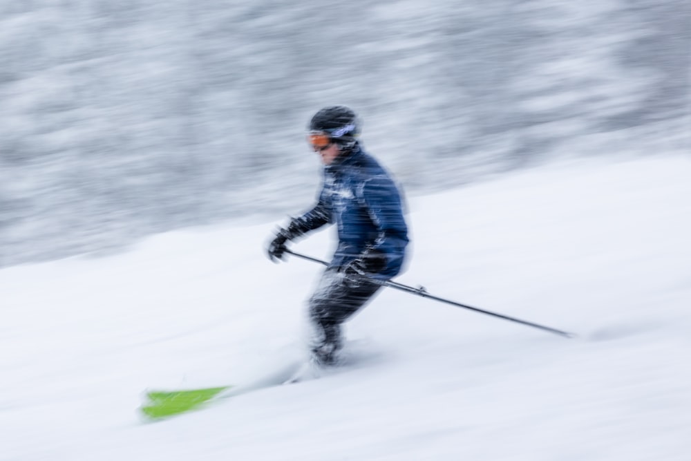 a man riding skis down a snow covered slope