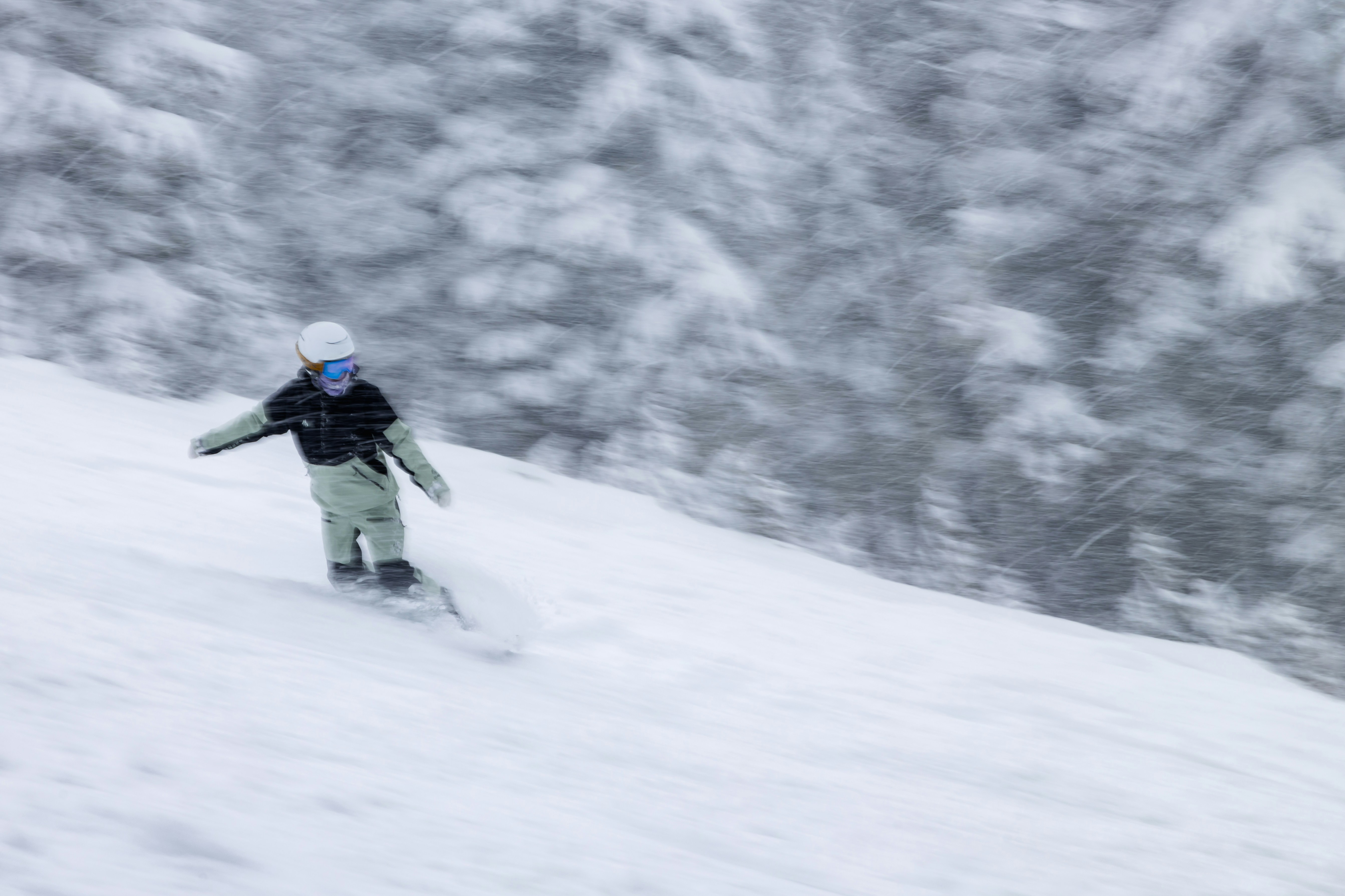 snowboarder going fast in powder and blowing snow