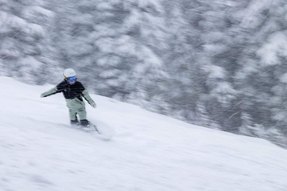 eine Person, die mit einem Snowboard einen schneebedeckten Hang hinunterfährt