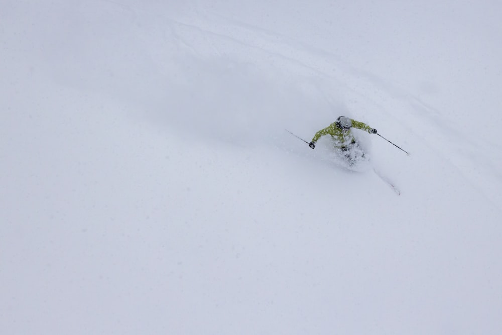una persona montando esquís por una pendiente cubierta de nieve