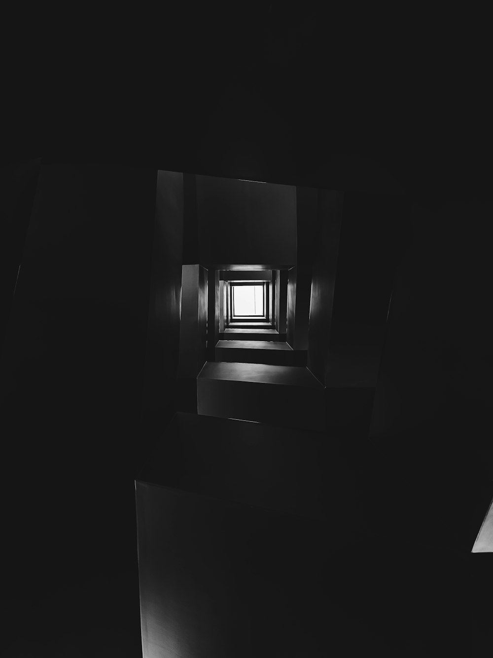 uma foto em preto e branco de uma janela em um quarto escuro