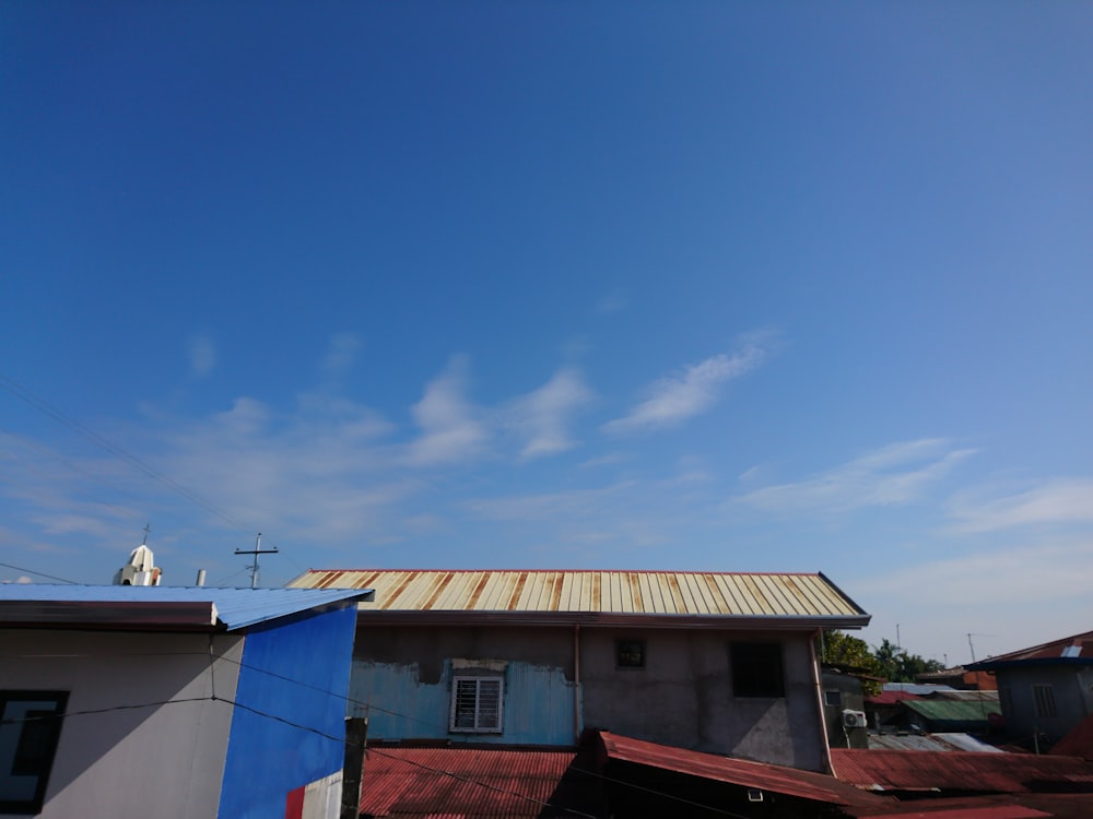 uma casa com um telhado de metal e um céu azul
