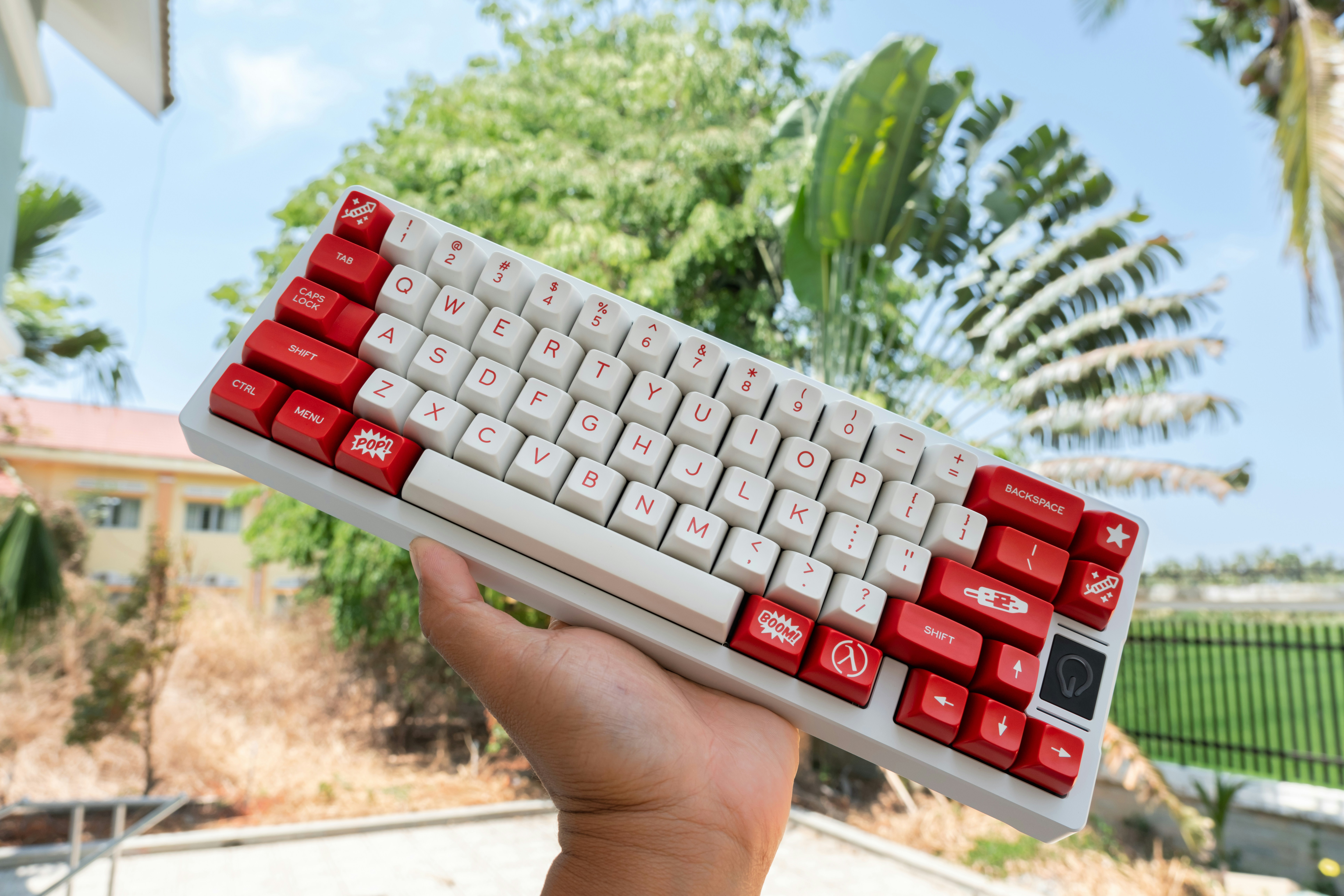 a hand holding a red and white keyboard