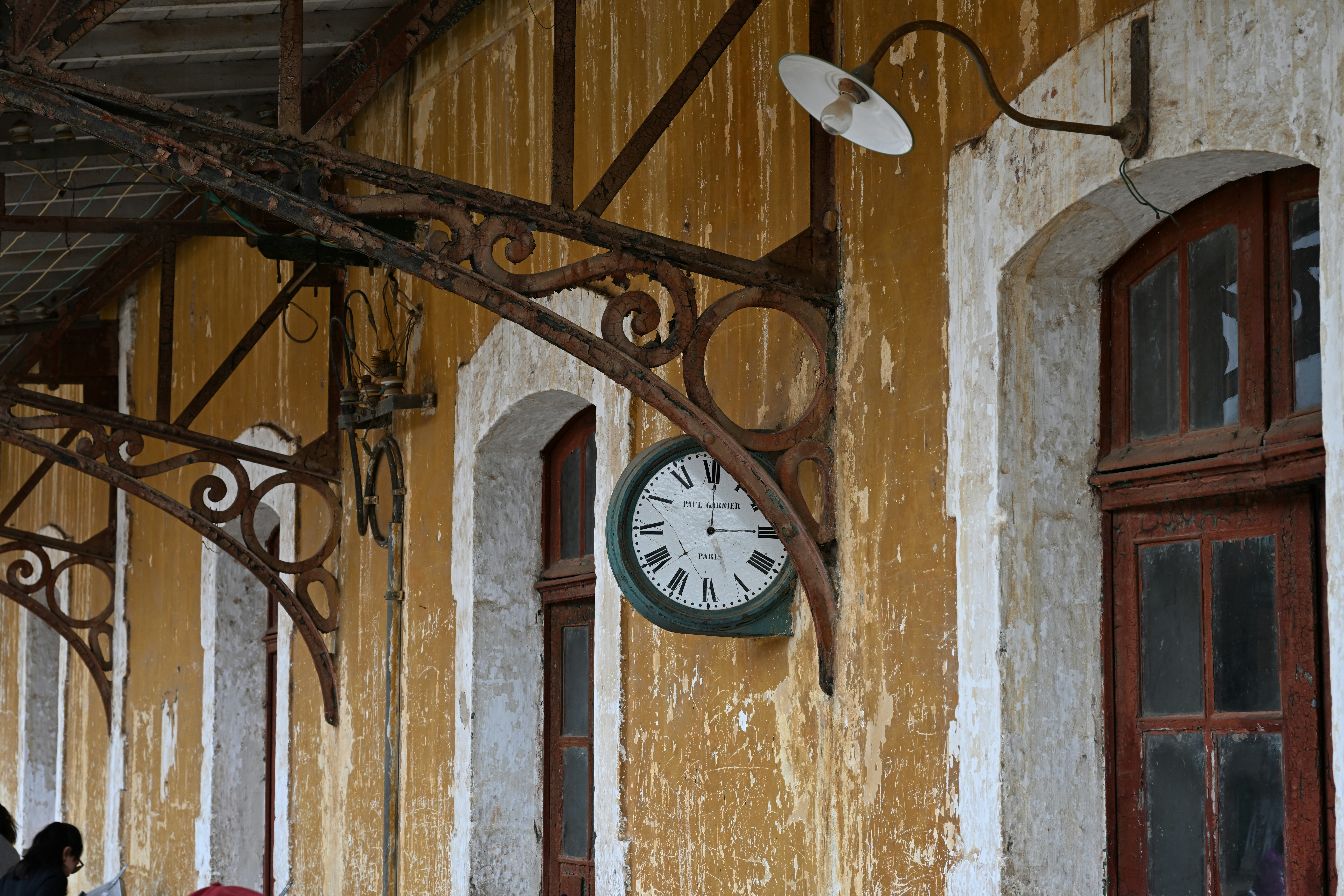A broken vintage wall clock hanging on a faded wall, moody light, symbolic and emotional