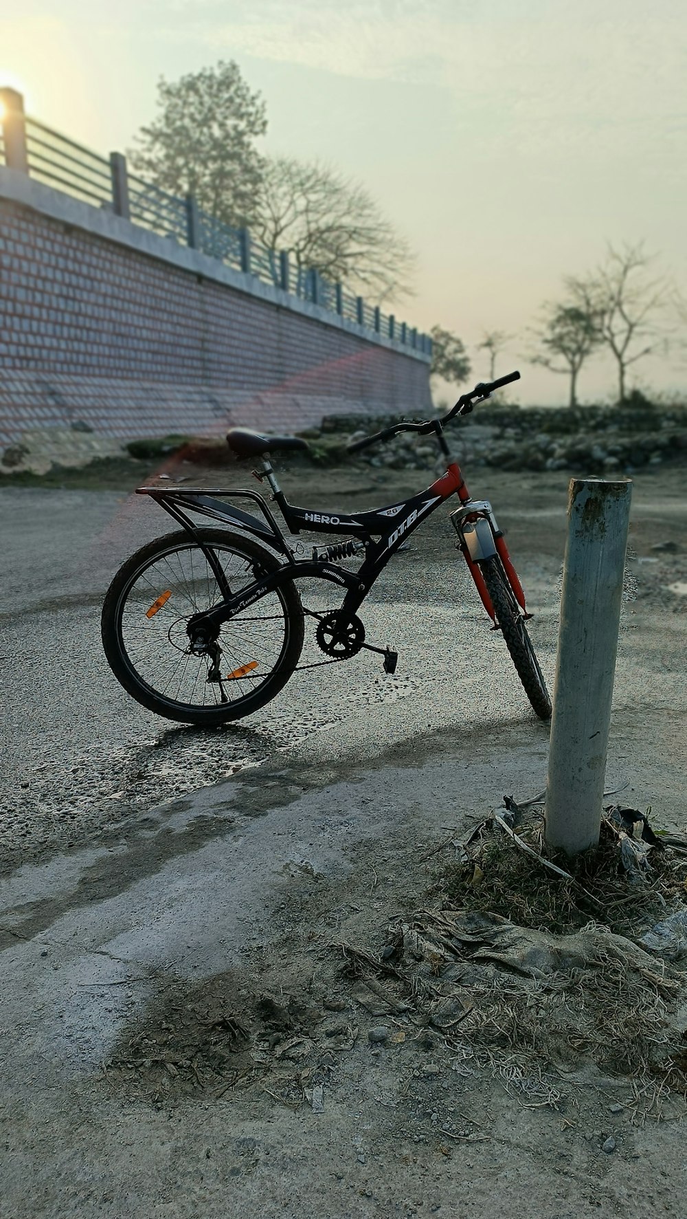 a bicycle leaning against a pole in a parking lot