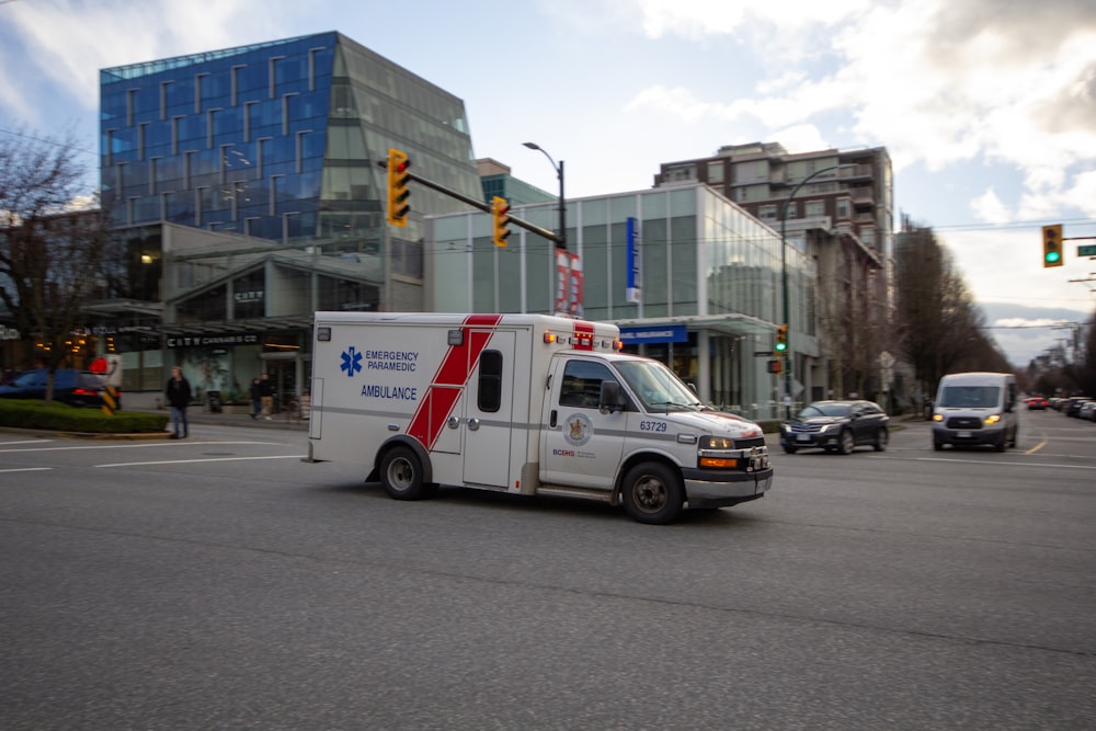 an ambulance driving down a city street next to tall buildings