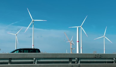 a car driving down a highway next to a bunch of windmills