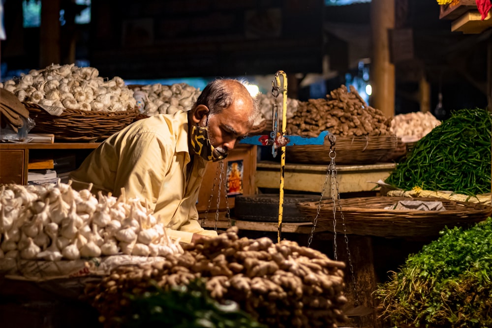 um homem em um mercado olhando para legumes