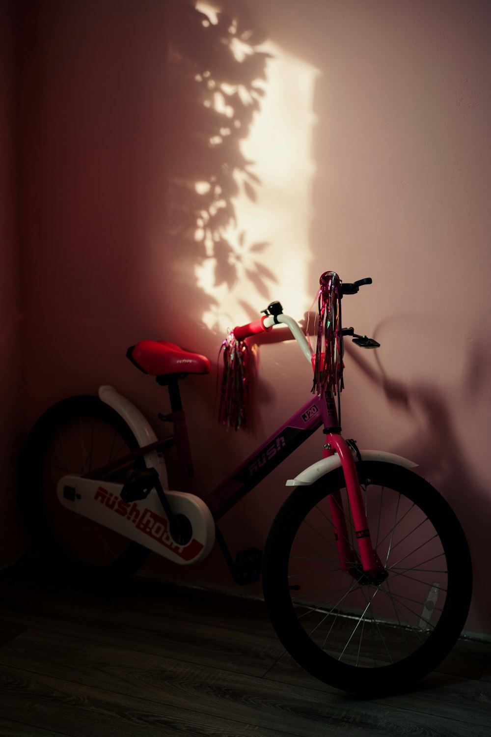 a bike is leaning against a pink wall