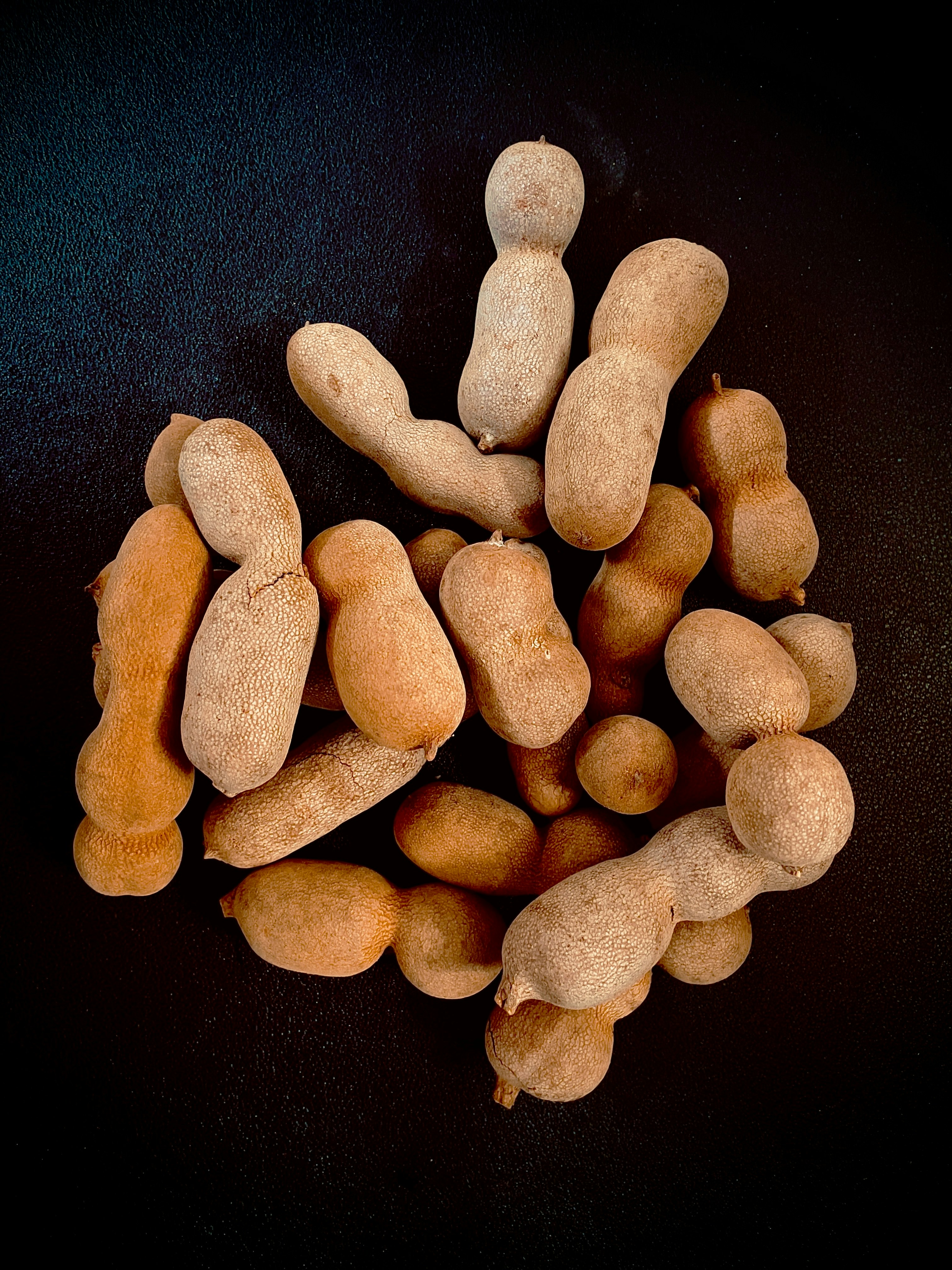 Whole tamarind pods in their brittle brown shells
