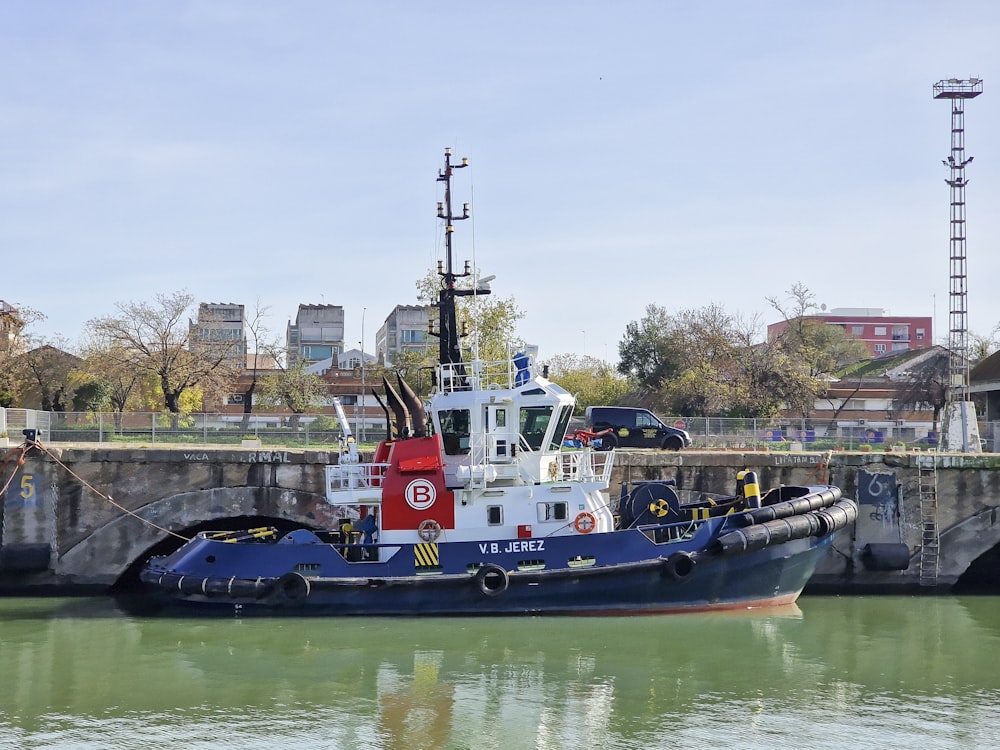 a tug boat in the water next to a bridge