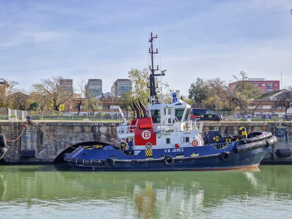 a blue and white tug boat in a body of water