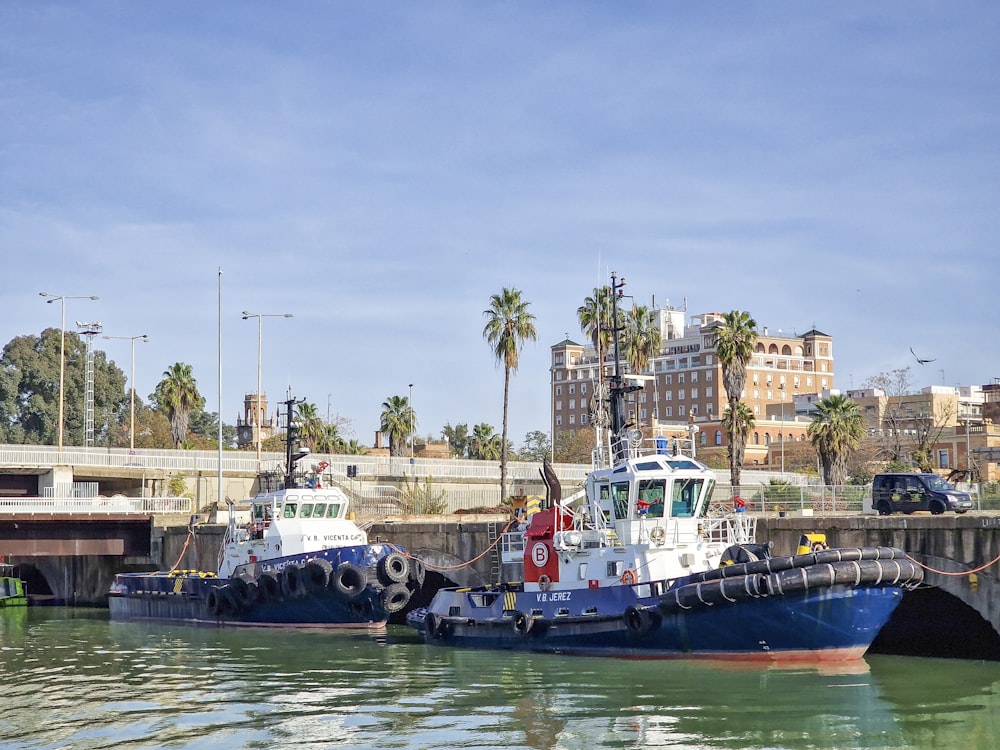 two tug boats are docked in the water