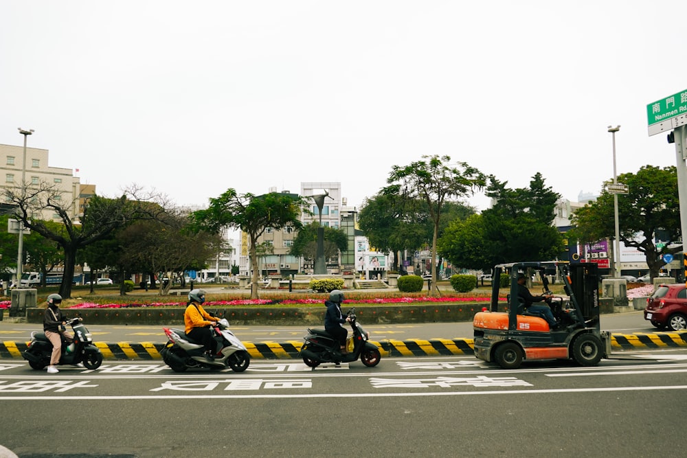 a group of people riding mopeds down a street