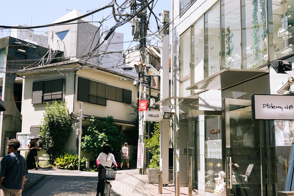 a group of people walking down a street next to tall buildings