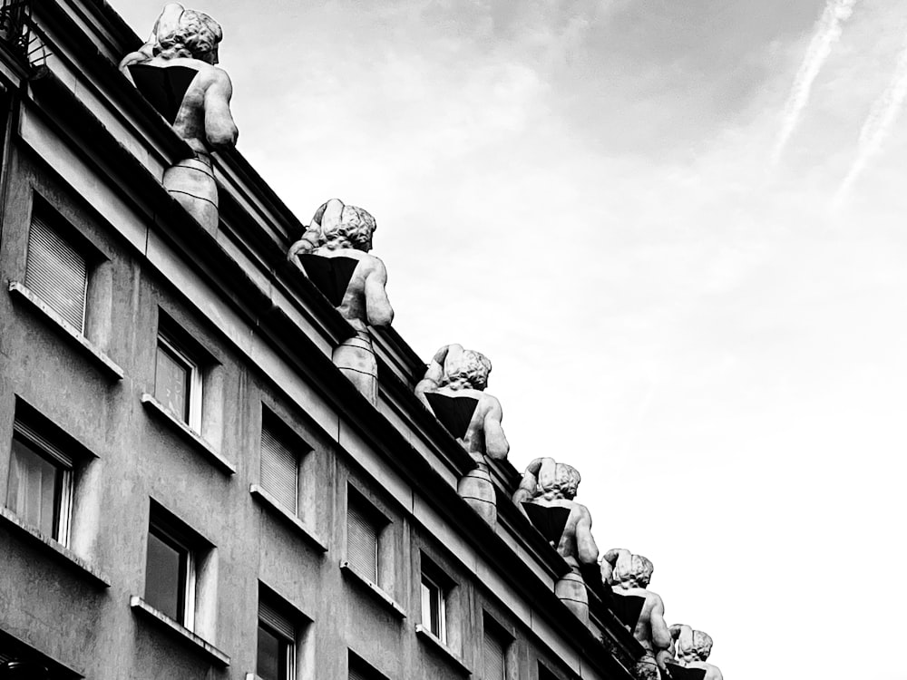 a black and white photo of a building with statues on it